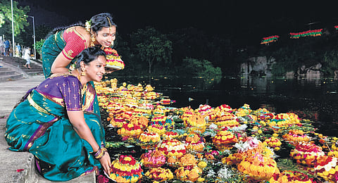 Women leave Bathukammas in the water after worshipping the goddess for nine days, in Warangal on Thursday