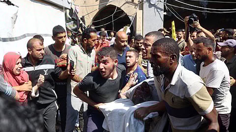 Palestinians carry an injured person after a strike hit the Rafida school sheltering displaced people in Deir al-Balah in the central Gaza Strip on October 10, 2024 amid the ongoing war between Israel and Hamas.