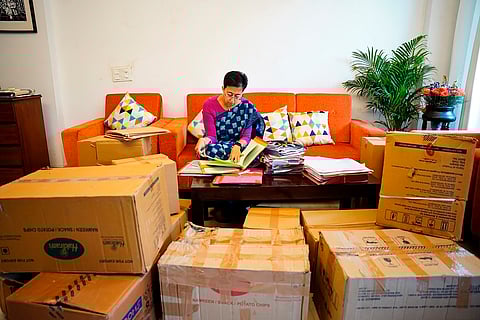 Delhi Chief Minister Atishi signing files surrounded by packed cartons of her belongings, at her Kalkaji residence in New Delhi on Thursday. 
