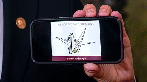 The head of the Nobel Committee, Jorgen Watne Frydnes, shows the logo of the Japanese organization Nihon Hidankyo, the winner of the Nobel Peace Prize for 2024, at the Nobel Institute in Oslo, Norway, Friday, Oct. 11, 2024.