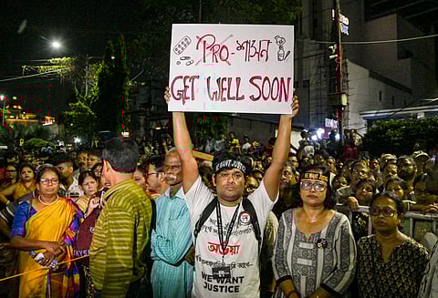 A man holds a placard during a 'mass convention' called by junior doctors near the hunger strike site, protesting against the alleged rape and murder of a trainee doctor, in Kolkata, Friday, Oct. 11, 2024. 