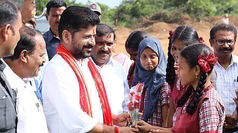 Chief Minister A Revanth Reddy interacts with students during the foundation stone laying programme for Young India Integrated Residential School at Shadnagar.