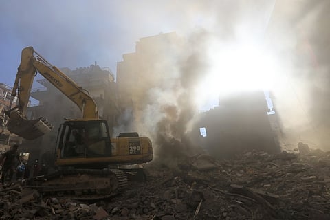 Members of the Lebanese civil defence dig through debris at the site of an Israeli strike on Beirut's Basta neighbourhood on October 11, 2024. 