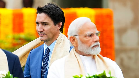 Canada's Prime Minister Justin Trudeau, left, walks past India's Prime Minister Narendra Modi