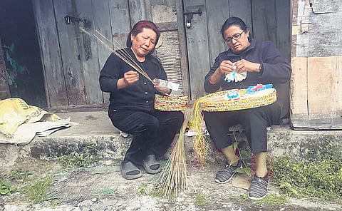 Women weaving baskets out of recycled material