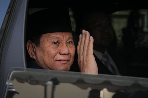 Indonesian president-elect Prabowo Subianto, waves to media as he leave for inauguration ceremony in Jakarta, Indonesia, Sunday.