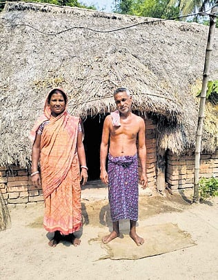 A couple in front of their thatched house in Kankan village