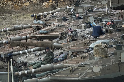 Israeli soldiers work on tanks in a staging area in northern Israel near the Israel-Lebanon border, on Oct 1, 2024.