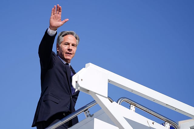 Secretary of State Antony Blinken waves as he boards a plane en route to the Middle East as he departs Joint Base Andrews.