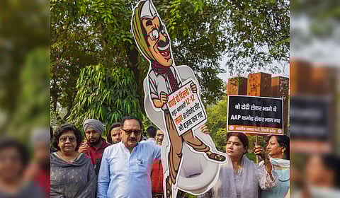 Delhi BJP President Virendra Sachdeva with party workers stages a protest against former Delhi chief minister Arvind Kejriwal, in New Delhi.