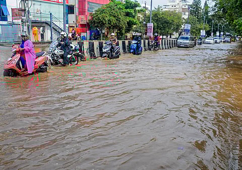 Vehicles move on a waterlogged road after heavy rain, in Bengaluru, Monday, October 21.