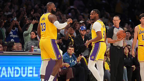 Los Angeles Lakers forward LeBron James (23) and guard Bronny James (9) during the first half of an NBA basketball game against the Minnesota Timberwolves in Los Angeles