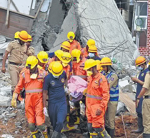 NDRF and fire personnel recover a body from the site of the collapse in Babusapalya on Wednesday. Search operations for the trapped labourers will continue
