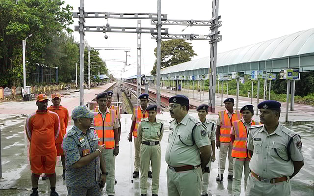 Security and NDRF personnel discuss precauionary measures ahead of the landfall of Cyclone 'Dana'.