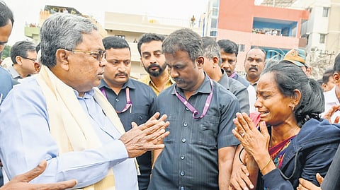 Chief Minister Siddaramaiah consoles a relative of a victim of the building collpase, in Bengaluru on Thursday.