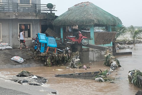 A man walks past damages caused by flash floods on Thursday Oct. 24, 2024 after Tropical Storm Trami, locally named Kristine, dumped heavy rains at Libon town, Albay province, Philippines.