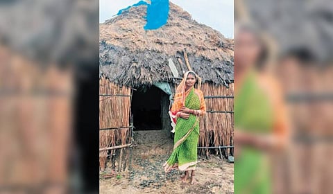 Radhika Mallik in front of her thatched house