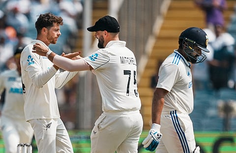 New Zealands Mitchell Santner celebrates with teammates after taking the wicket of Indias captain Rohit Sharma on the third day of the second test cricket match between India and New Zealand in Pune, Saturday, Oct. 26, 2024. 