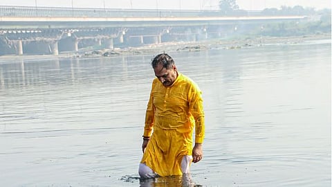 Delhi BJP President Virendra Sachdeva takes a dip in the Yamuna river to mark his protest against the Delhi government with the rising pollution in the river as well as the city, in New Delhi on Thursday.
