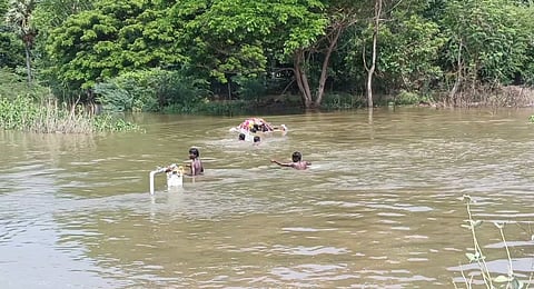 Arunachalam's body being carried to the cemetery in neck-deep water by relatives on Saturday