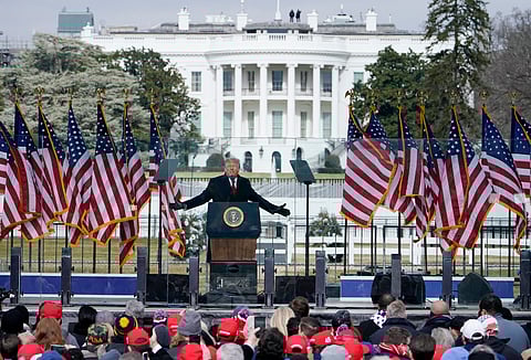 With the White House in the background, President Donald Trump speaks at a rally in Washington, Jan. 6, 2021. 