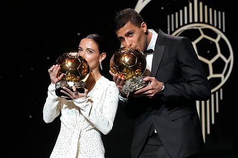 Barcelona's Spanish player Aitana Bonmati, left, and Manchester City's Spanish player Rodri kiss their 2024 Ballon d'Or trophies during the 68th Ballon d'Or (Golden Ball) award ceremony at Theatre du Chatelet in Paris, Monday, Oct. 28, 2024.
