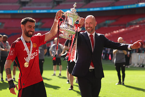 Erik ten Hag and Bruno Fernandes pose with the trophy after winning the English FA Cup final between Manchester City and Manchester United at Wembley Stadium in London.