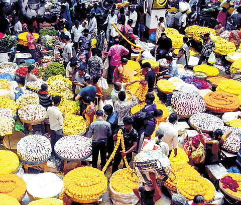People shop for flowers ahead of Deepavali at K R Market in Bengaluru on Wednesday
