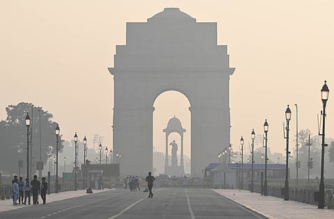 A woman crosses the Kartavya Path amid low visibility due to smog as air quality remains in 'severe' category, in New Delhi, Monday, Nov. 18, 2024. 