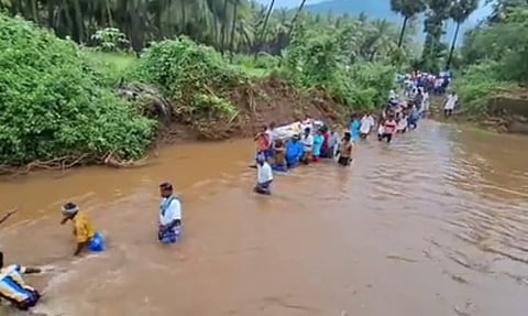 Villagers taking the mortal remains of elderly man across the river for burial in Natham in Dindigul district.