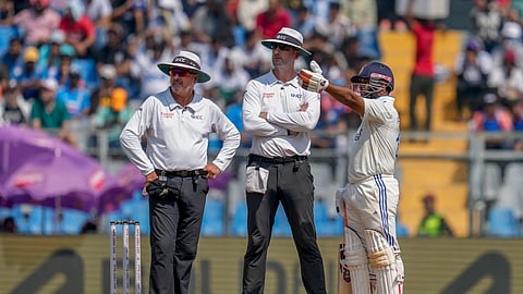Rishab Pant speaks to umpires Michael Gough, center, and Richard Illingworth after his dismissal during the third day of the third cricket test match between India and New Zealand at Wankhede Stadium, in Mumbai.
