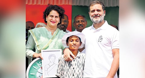 Congress leaders Priyanka Gandhi Vadra and Rahul Gandhi with a boy who gifted the former with her portrait at Mananthavady during election campaign