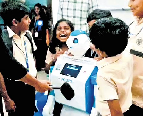 Students surround humanoid robot Poopy after it was introduced at the 
Govt UP School, Virakupurakotta