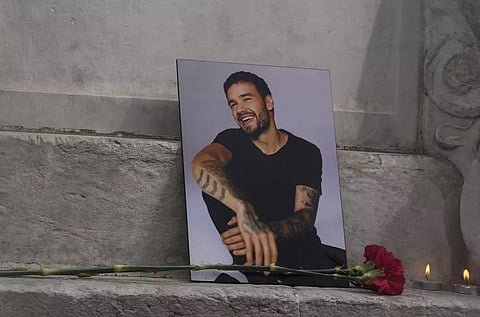 A photo of former One Direction singer Liam Payne is placed with a rose and candles as fans gather in Madrid, Spain, Sunday, Oct. 20, 2024, after the British pop singer fell to his death from a hotel balcony in Argentina. 