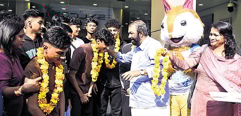 Education Minister V Sivankutty receives the students from UAE after they landed in Kochi for the sports meet on Monday 
