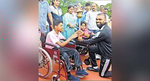 Anoop Binu from Koonammavu Chavara Vocational Training Centre and Yashwitha A from St Joseph’s UP School, Karithala, pass the torch to hockey star 
P R Sreejesh
