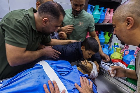 The son and relatives of Palestinian Mohammad al-Aasaoussi who was killed during an Israeli army raid earlier near Qabatiya town, mourn by his body at the Jenin public hospital morgue in the occupied West Bank on November 5, 2024.