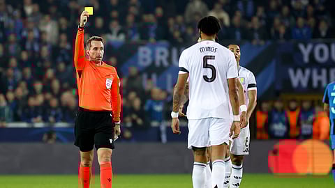 German referee Tobias Stieler shows the yellow card to Aston Villa's Tyrone Mings during the Champions League opening phase football match between Club Brugge and Aston Villa at Jan Breydelstadion in Bruges, Belgium.