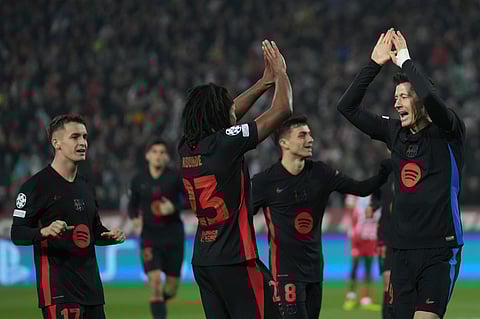 Barcelona's Robert Lewandowski, right, celebrates after scoring during the Champions League opening phase football match between Red Star and Barcelona at the Rajko Mitic Stadium in Belgrade, Serbia.