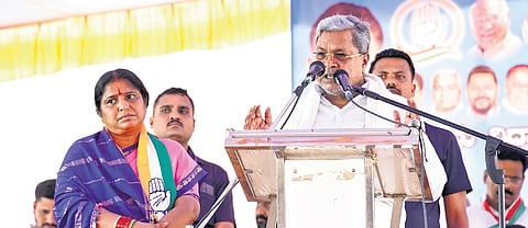 Chief Minister Siddaramaiah addresses voters in Sandur, as Congress candidate Annapoorna Tukaram looks on, on Friday