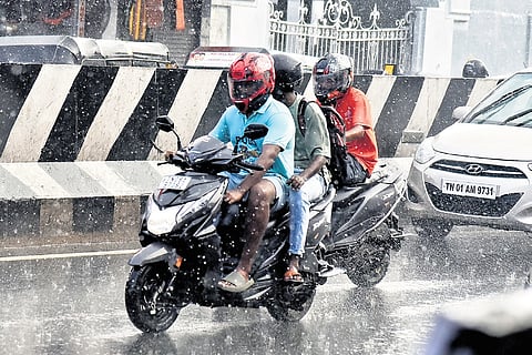 Motorists ride through rain on Mount Road in Chennai on Friday
