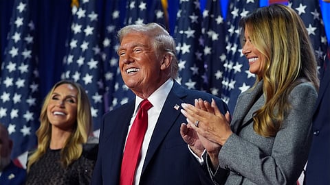 Republican presidential nominee former President Donald Trump stands on stage with former first lady Melania Trump, as Lara Trump watches, at an election night watch party at the Palm Beach Convention Center, Wednesday, Nov. 6, 2024, in West Palm Beach, Fla.
