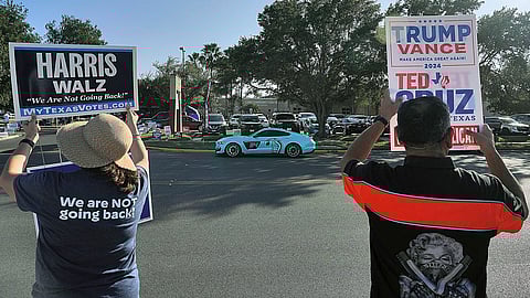 Supporters of democratic presidential nominee Vice President Kamala Harris and Republican presidential nominee former President Donald Trump campaign outside a polling place.