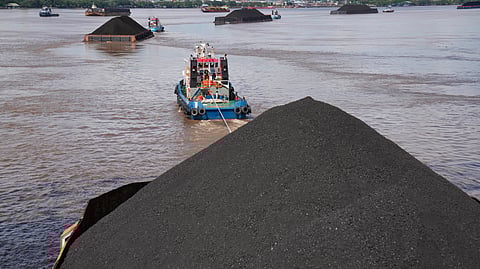 Tug boats pull barges fully loaded with coal on the Mahakam River in Samarinda, East Kalimantan, Indonesia