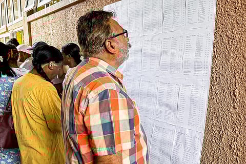 Voters check the electoral roll before at a polling station during the 2024 Mauritian general election at Beau Vallon, in Mahebourg on November 10, 2024.