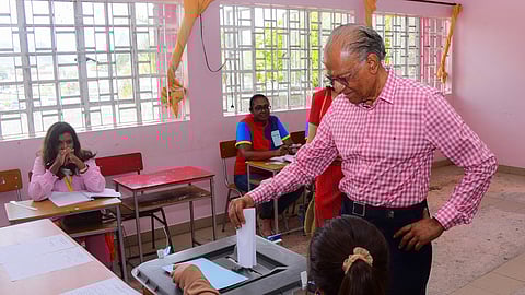 Former Prime Minister of Mauritius and candidate for Alliance du Changement, Navin Ramgoolam (R), casting his ballot during the 2024 Mauritian general election.
