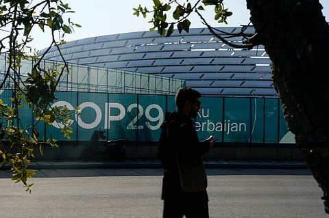 A person walks outside the Baku Olympic Stadium, the venue for the COP29 U.N. Climate Summit, Sunday, Nov. 10, 2024, in Baku, Azerbaijan.