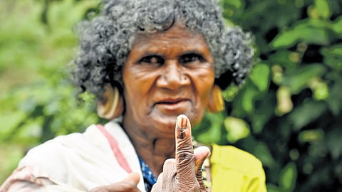 A woman showing her inked finger after casting vote in Wayanad