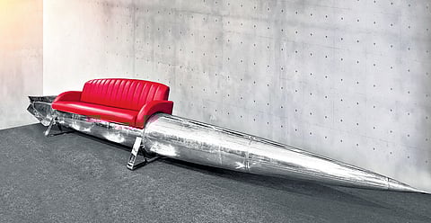 Red napa leather sofa, nestling in the heart of an erstwhile 18-foot drop tank from a MiG-21 fighter jet