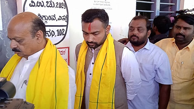 Haveri MP and ex-CM Basavaraj Bommai and Shiggaon BJP candidate Bharat Bommai wait to vote on Wednesday 